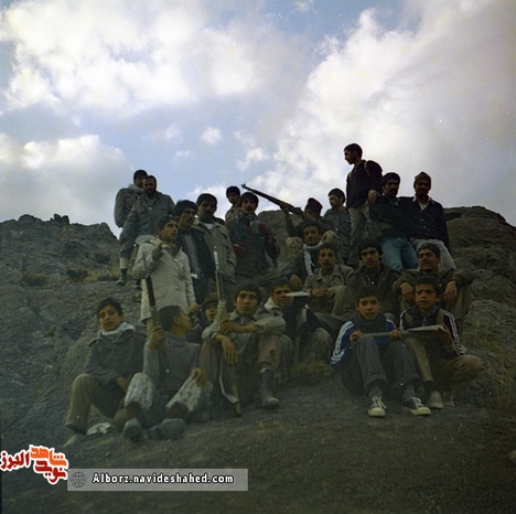 شهید علی زحمتیان شریف آبادی در جمع همکلاسی‌ها و در کنار رزمندگان